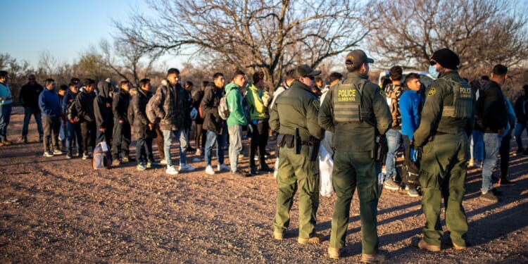 A group of migrants are processed by Border Patrol after crossing the river illegally near the highway on Feb. 4 outside Eagle Pass, Texas.