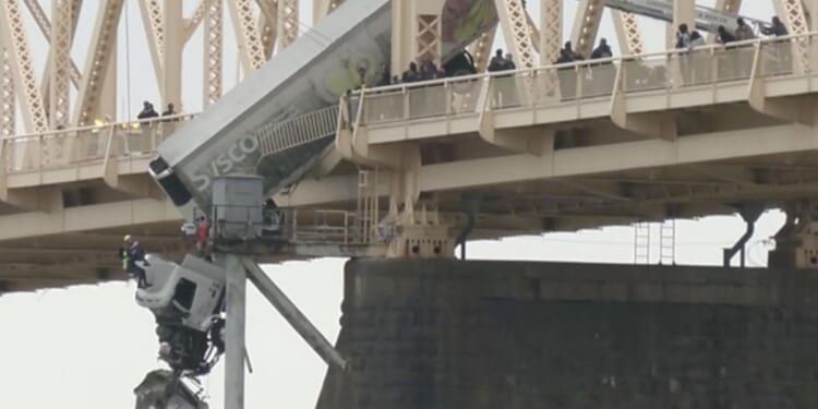 Truck driver rescued from cab dangling off a Louisville bridge