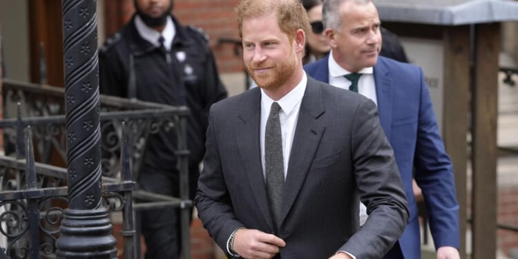 Prince Harry says tabloids intercepted phone calls of mother, the late Princess Diana, and father