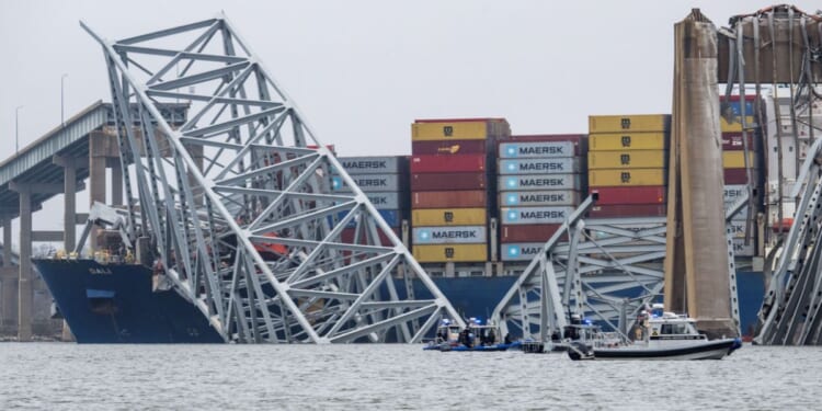 The collapsed Francis Scott Key Bridge lies on top of the container ship Dali in Baltimore on Wednesday.