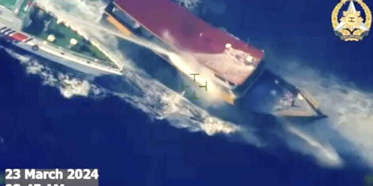 In this screen grab from video, a Chinese coast guard ship uses water cannons and closely maneuvers beside a Philippine resupply vessel as it approaches Second Thomas Shoal, at the disputed South China Sea on Saturday.