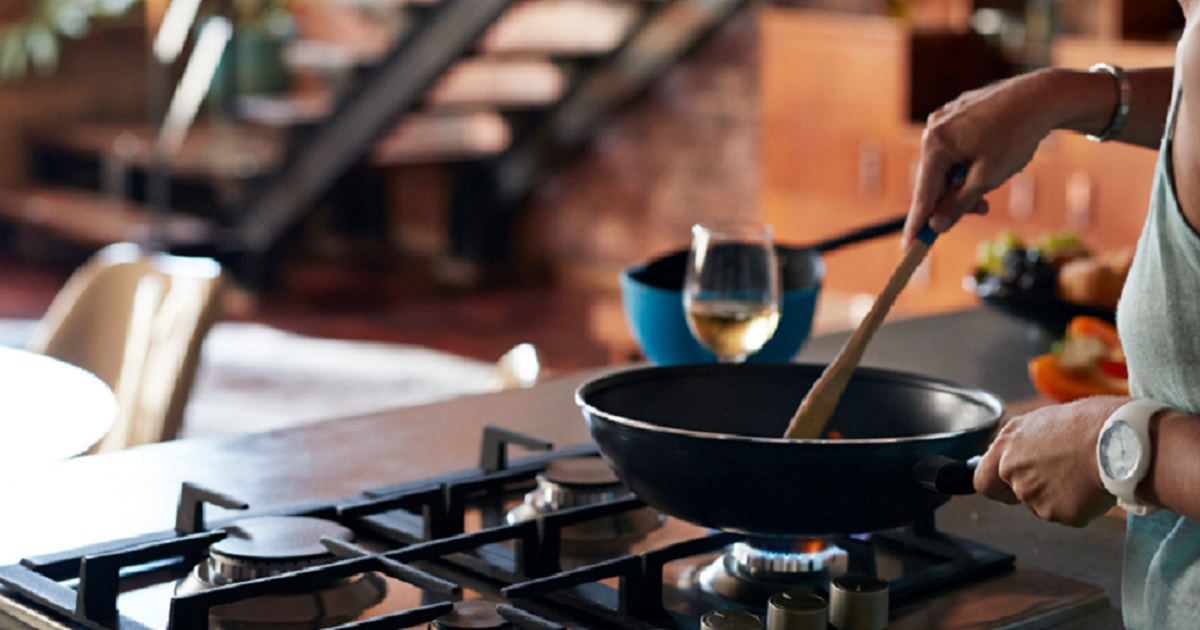 A woman cooking over a gas burner.