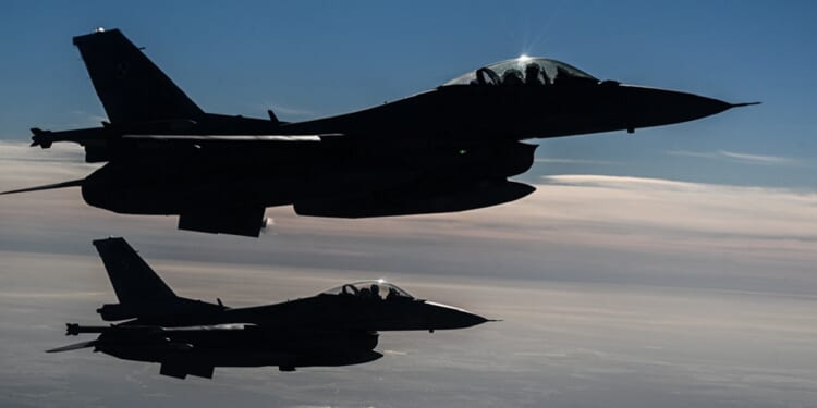 Airborne Polish Air Force F-16s are pictured in an October 2022 file photo from NATO exercises in Lask, Poland.