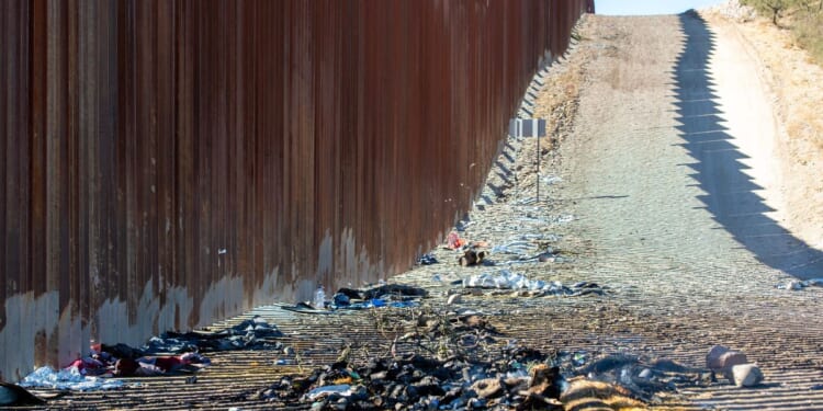 Ashes from a bonfire and clothes are pictured next to the U.S.-Mexico border wall in Sasabe, Arizona, on Dec. 5.