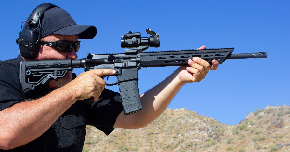 A stock photo shows a man firing an AR-15-style rifle at a range.