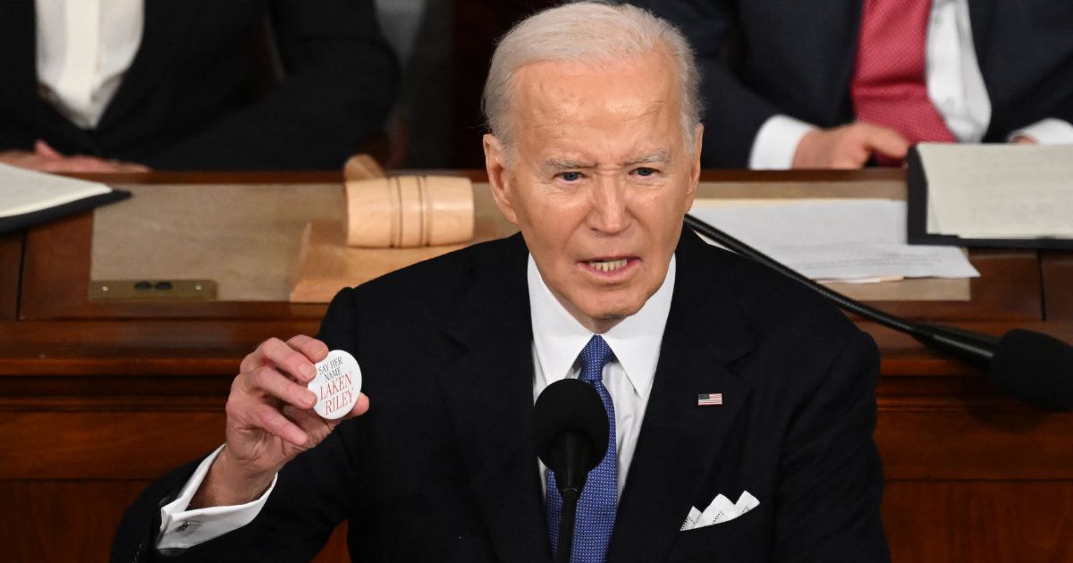 President Joe Biden holds a Laken Riley button while delivering the State of the Union address in the House Chamber of the U.S. Capitol in Washington, D.C. Thursday.