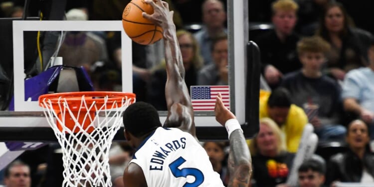 Minnesota Timerwolves shooting guard Anthony Edwards dunks over Utah Jazz John Collins during Monday's game in Salt Lake City, Utah.