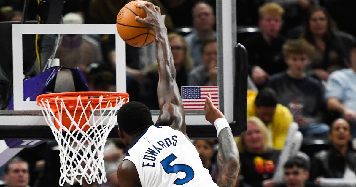 Minnesota Timerwolves shooting guard Anthony Edwards dunks over Utah Jazz John Collins during Monday's game in Salt Lake City, Utah.