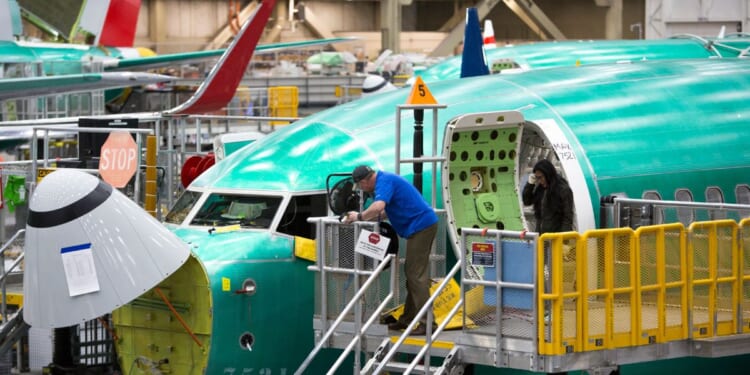 Employees work on Boeing 737 MAX airplanes at the Boeing Factory in Renton, Washington, in this file photo from March 2019.