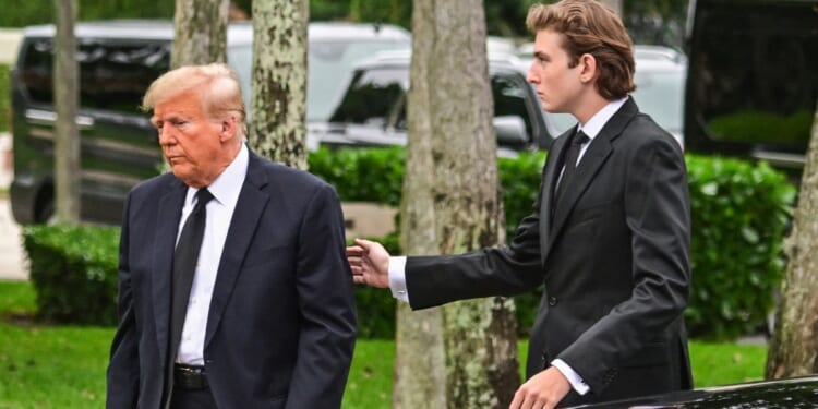 Former President Donald Trump is seen with his son Barron Trump in a file photo from January. Barron Trump turned 18 Wednesday.