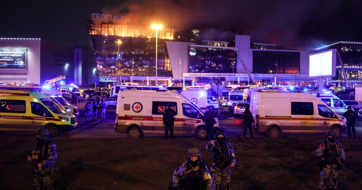 Law enforcement officers are seen deployed outside the burning Crocus City Hall in Krasnogorsk, outside Moscow, on Friday.