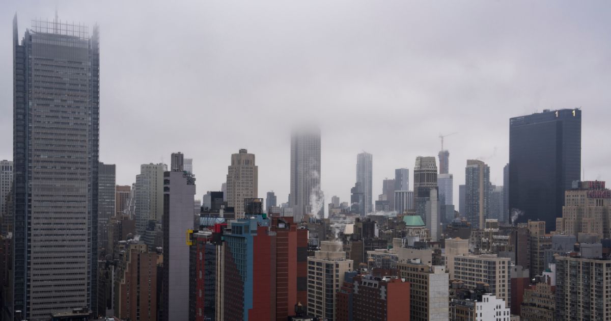 An aerial view shows the top of the Empire State Building in New York covered in clouds on a rainy day on Jan. 26.