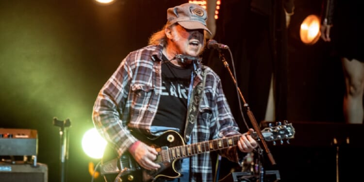 Music star Neil Young performs on stage in an April 2023 file photo from the Autism Speaks Light Up The Blues 6 Concert at The Greek Theatre in Los Angeles.