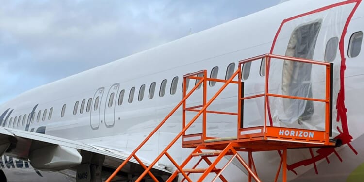 Plastic covers the exterior of the fuselage plug area of Alaska Airlines Flight 1282 on Jan. 7 in Portland, Oregon. A piece of the fuselage of the Boeing 737 MAX 9 plane blew off after the flight left Portland on Jan. 5 en route to Ontario, California.