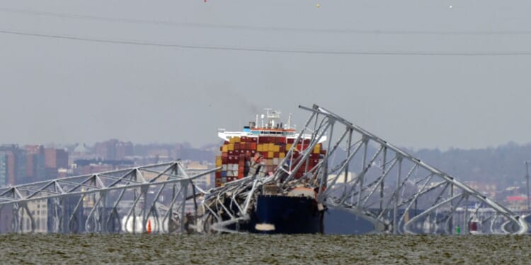 A container ship rests against wreckage of the Francis Scott Key Bridge in Baltimore, Maryland, on Tuesday.