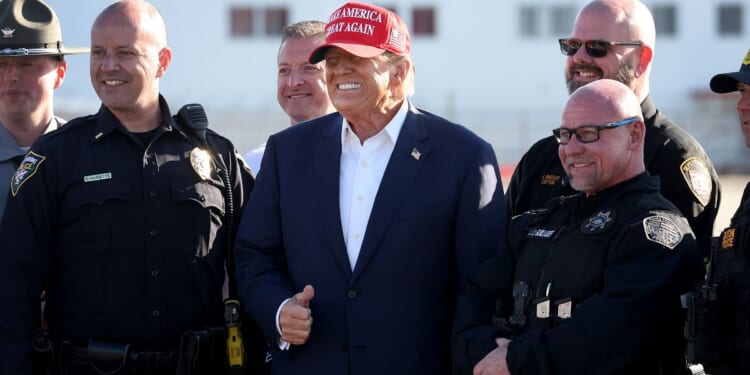 Republican presidential candidate and former President Donald Trump poses with law enforcement officers following a rally at the Dayton International Airport in Vandalia, Ohio, on Saturday.