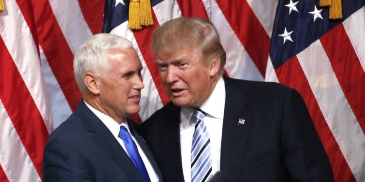 Then-presidential candidate Donald Trump, right, shakes hands with his vice presidential running mate Mike Pence in a file photo from July 2016.