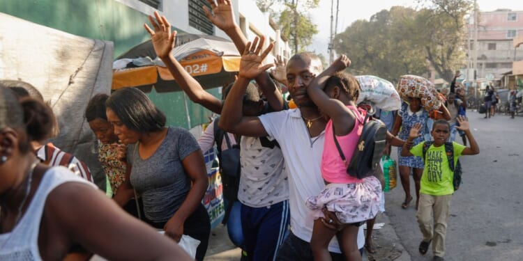 Residents flee their homes during clashes between police and gang member at the Portail neighborhood in Port-au-Prince, Haiti, on Thursday.