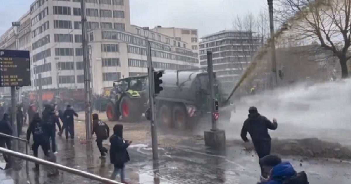 During a protest last week in Brussels, Belgium, farm vehicle sprays liquid manure while a police water cannon tries to disperse the waste.