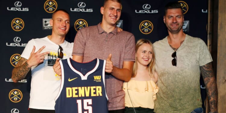 Nikola Jokić, center left, poses with Nemanja Jokić, left, Natalija Macesic, center right, and Strahinja Jokić, right, during a news conference to outline a contract extension in Denver, Colorado, on July 9, 2018.