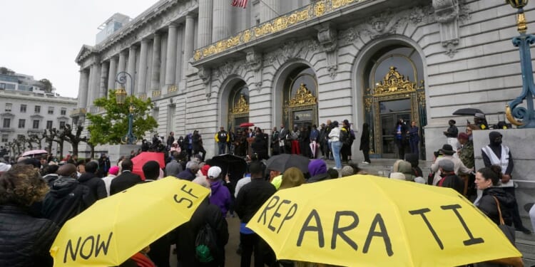 A crowd listens to speakers at a reparations rally outside of City Hall in San Francisco, in a file photo from March 14, 2023.