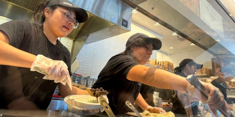 Workers fill food orders at a Chipotle restaurant in San Rafael, California, on April 1.