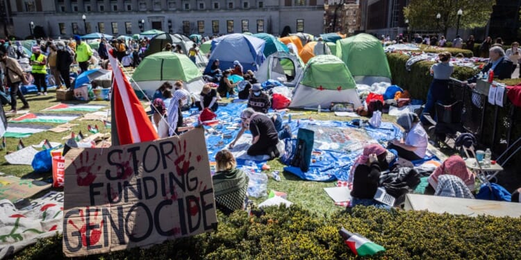 a sign saying "stop funding genocide" sits at the border of the anti-Israel demonstration encampment at Columbia University