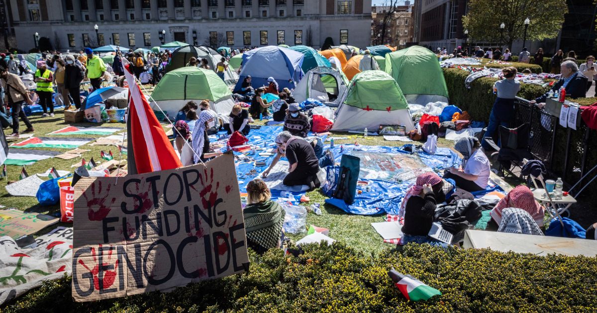 a sign saying "stop funding genocide" sits at the border of the anti-Israel demonstration encampment at Columbia University