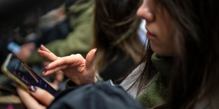 A subway passenger reads her iPhone in New York City on March 27.