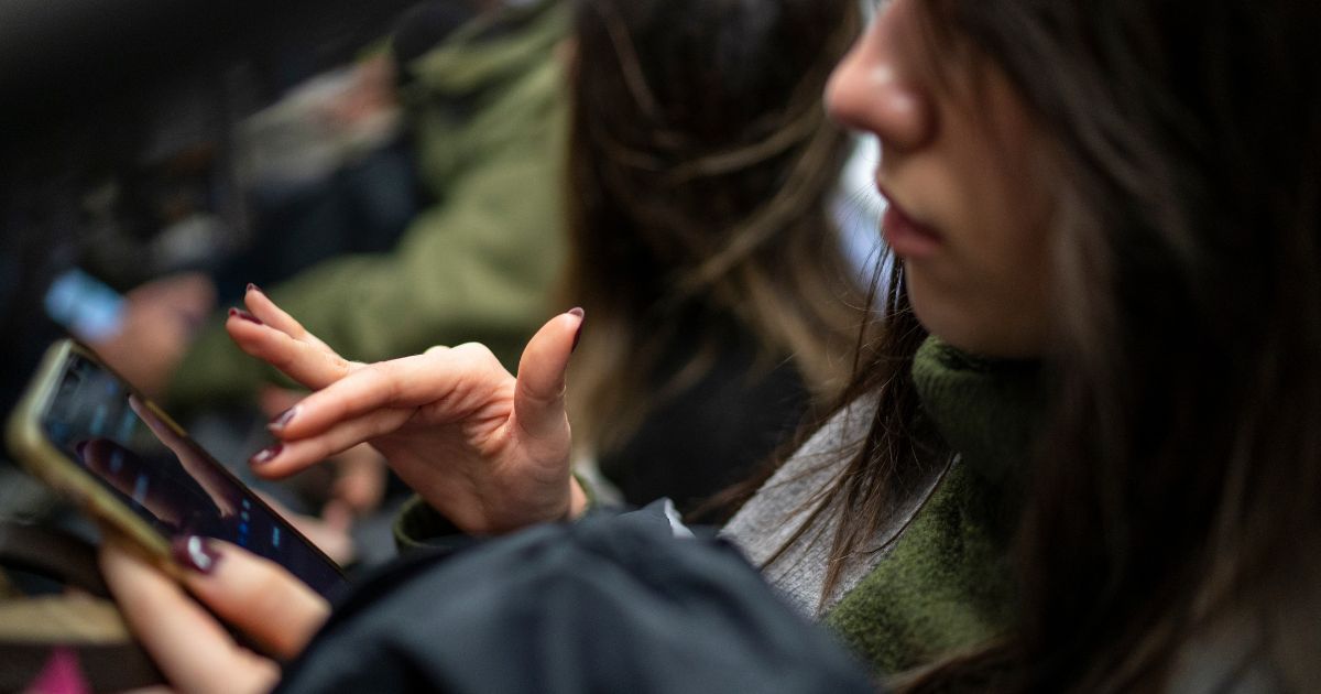 A subway passenger reads her iPhone in New York City on March 27.