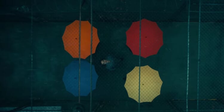 The titular character from the upcoming film "Joker: Folie à Deux" surrounded by colorful umbrellas.