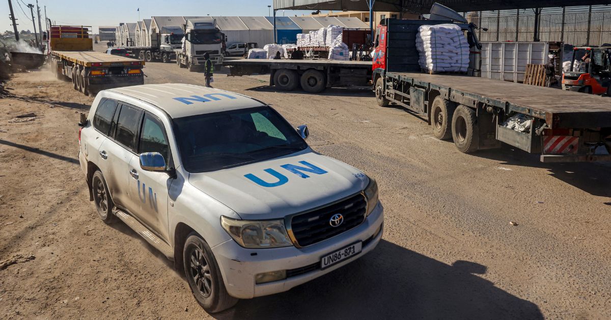 A United Nations vehicle drives past trucks delivering humanitarian aid to Gaza on Feb. 17.