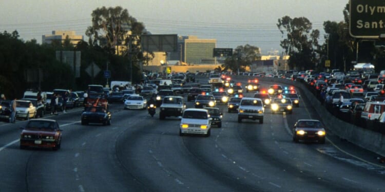 Police cars pursue the Ford Bronco driven by Al Cowlings, carrying fugitive murder suspect O.J. Simpson, on a 90-minute slow-speed car chase June 17, 1994 on the 405 freeway in Los Angeles, California.