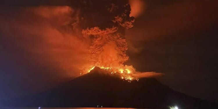 Indonesians evacuate from homes near erupting volcano and airport closes due to ash danger