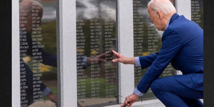 President Joe Biden reaches to touch the name of his uncle Ambrose J. Finnegan, Jr., on a wall at a Scranton World War II memorial, Wednesday in Scranton, Pennsylvania. News outlets contradicted Biden's insinuation that his uncle was eaten by cannibals.