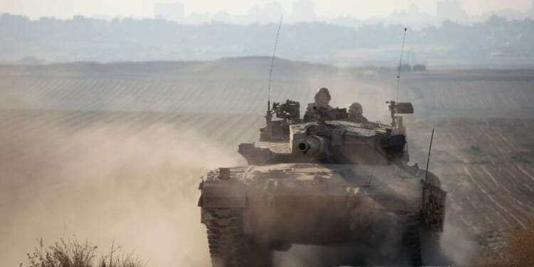 An Israeli tank moves along the border with the Gaza Strip on Sunday in southern Israel.