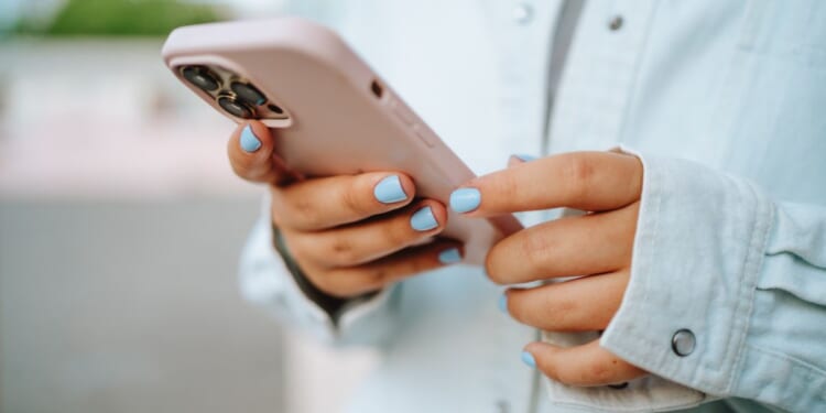 This stock image shows a girl using a cell phone.