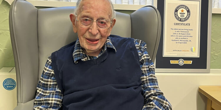 John Alfred Tinniswood, 111, poses in a photo issued Saturday by Guinness World Records.