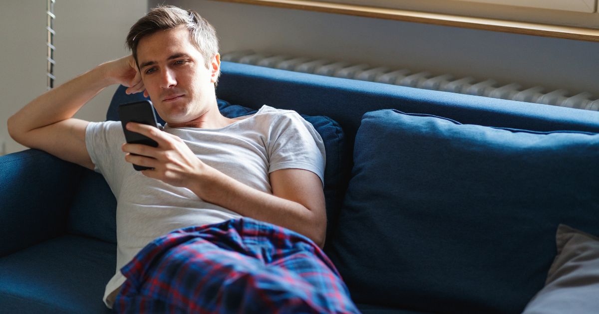 A man looks at a cellphone in this stock image.