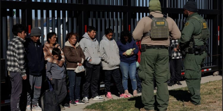 U.S. Border Patrol agents guard migrants who crossed into the U.S. in Eagle Pass, Texas, in a file photo from Feb. 4.