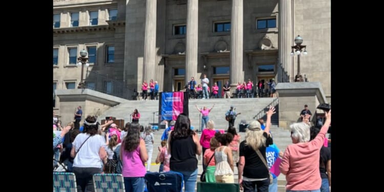 This image shows a crowd outside Idaho's capitol building attending a “Don’t Mess With Our Kids” prayer rally initiated by Her Voice Movement on Saturday.