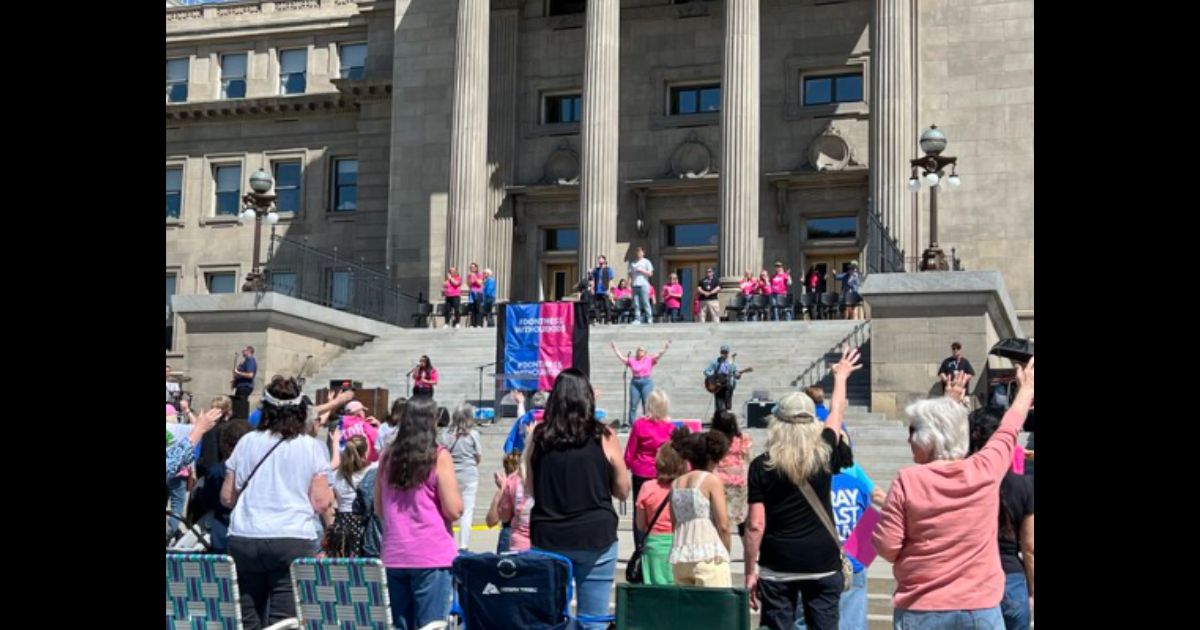 This image shows a crowd outside Idaho's capitol building attending a “Don’t Mess With Our Kids” prayer rally initiated by Her Voice Movement on Saturday.