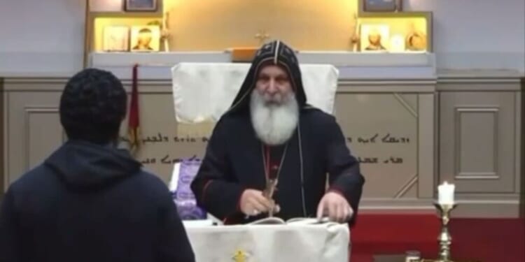 An unidentified man approaches Bishop Mar Mari Emmanuel while he conducts the Sunday evening service at the Assyrian Christ the Good Shepherd Church in Wakeley, Australia.