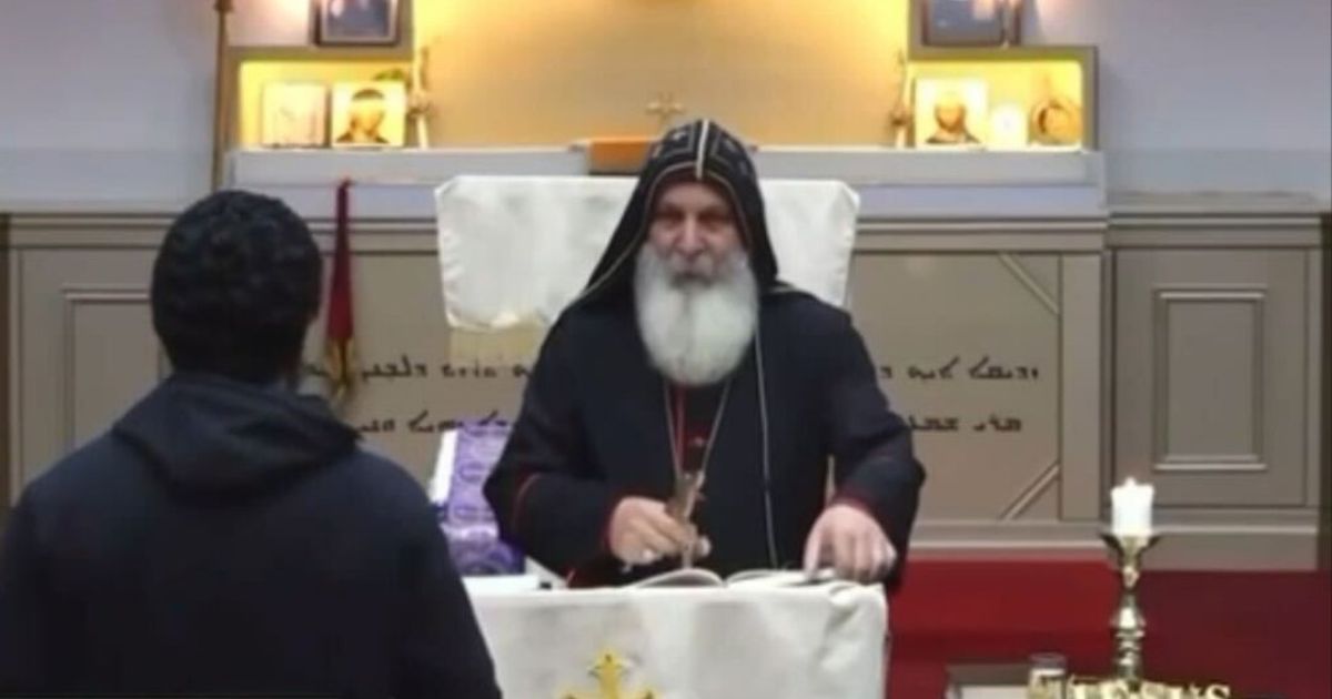 An unidentified man approaches Bishop Mar Mari Emmanuel while he conducts the Sunday evening service at the Assyrian Christ the Good Shepherd Church in Wakeley, Australia.