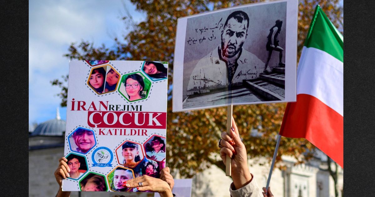 People hold placards bearing portraits of imprisoned Iranian rapper Toomaj Salehi , right, and portraits of children, left , who were killed during protests in Iran in a file photo from November 2022. Salehi has reportedly been sentenced to death for his criticism of the Iranian regime.