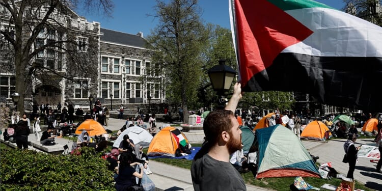 A white man holds a Palestinian flag during a protest at the City University of New York on April 25.