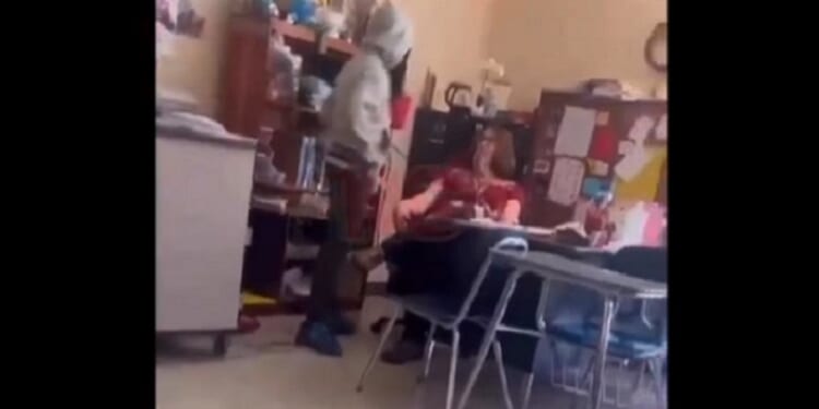 A student hovers over a teacher before delivering a second slap in a classroom confrontation on April 15 in Winston-Salem, North Carolina.