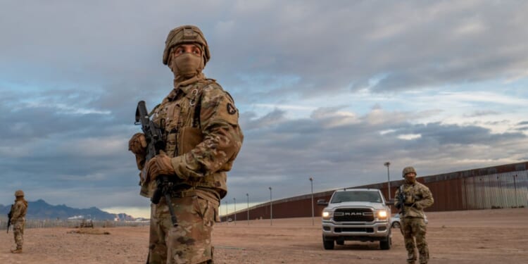 Texas National Guard soldiers stand on patrol near the banks of the Rio Grande on Tuesday in El Paso, Texas.