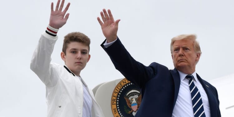 Then-President Donald Trump, right, and his son Barron Trump, left, wave from the top of the steps to Air Force One in Morristown, New Jersey, on Aug. 16, 2020.