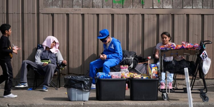 People sit outside a migrant shelter on March 13 in the Pilsen neighborhood of Chicago.